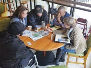 TNC Community individuals gathered around table with staff
