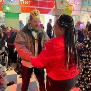 TNC Community individual John dances with staff