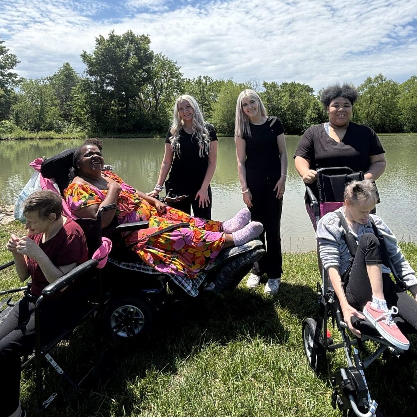 TNC Community individuals and staff by the pond at Spring Fun Day.